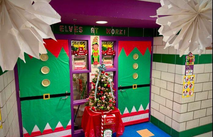  two door decorated as elves with a christmas tree and mailbox in the middle of them.